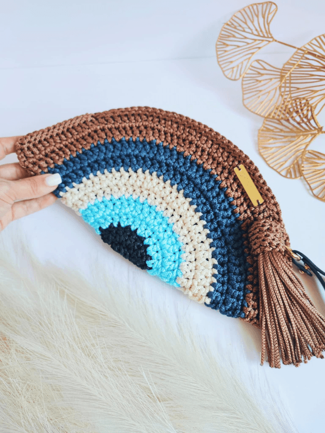 Sac Clutch mauvais œil fait main en crochet, pochette Nazar avec dragonne, fermeture zippée et pompon – accessoire artisanal en polyester (1)